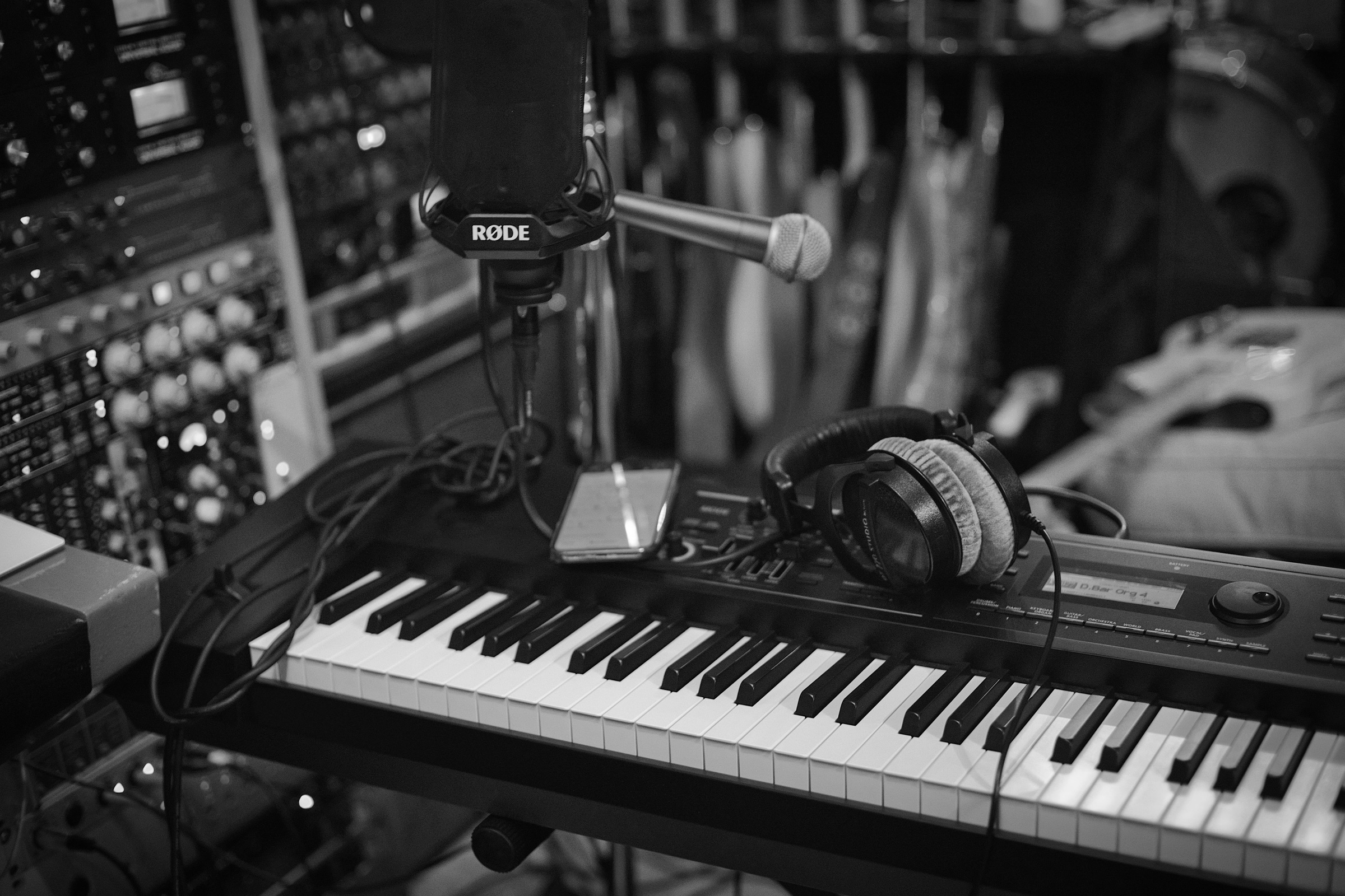 Mikrofon, keyboard, hörlurar och rackutrustning i en inspelningsstudio